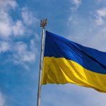 Ukraine Flag - blue and yellow flying in the wind with a blue sky backdrop