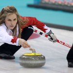 Female athlete playing winter sport of curling on the ice